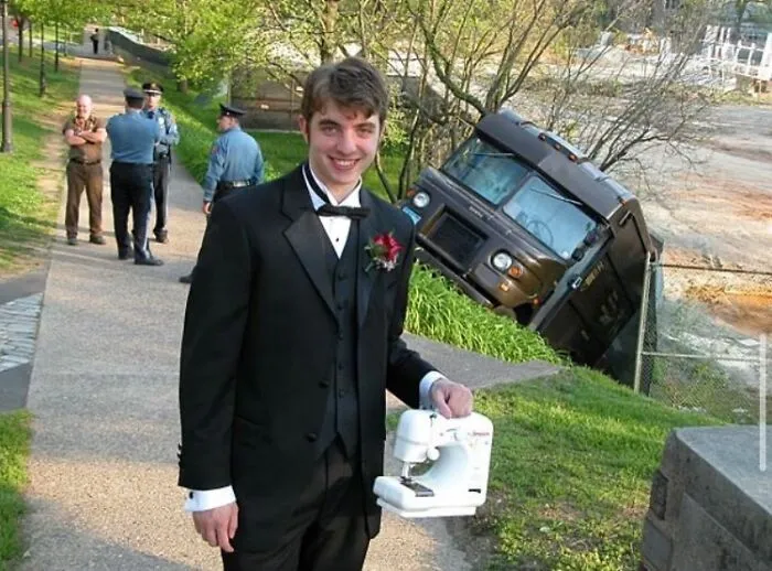 A man in a tuxedo holding a sewing machine next to an overturned truck, one of many cursed images.