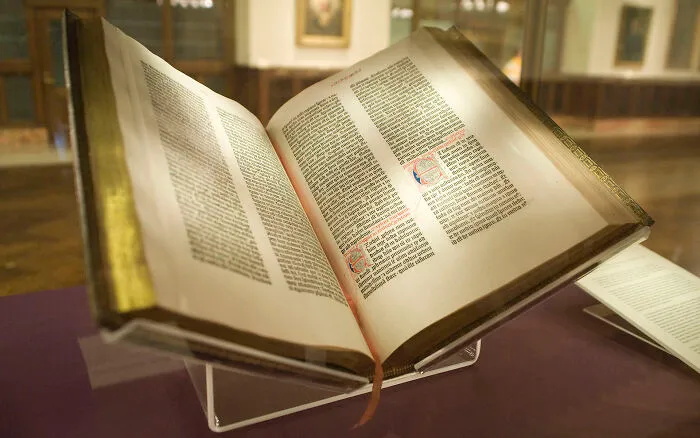 An open Gutenberg Bible, a historical book, displayed on a stand, representing amazing world records in printing.