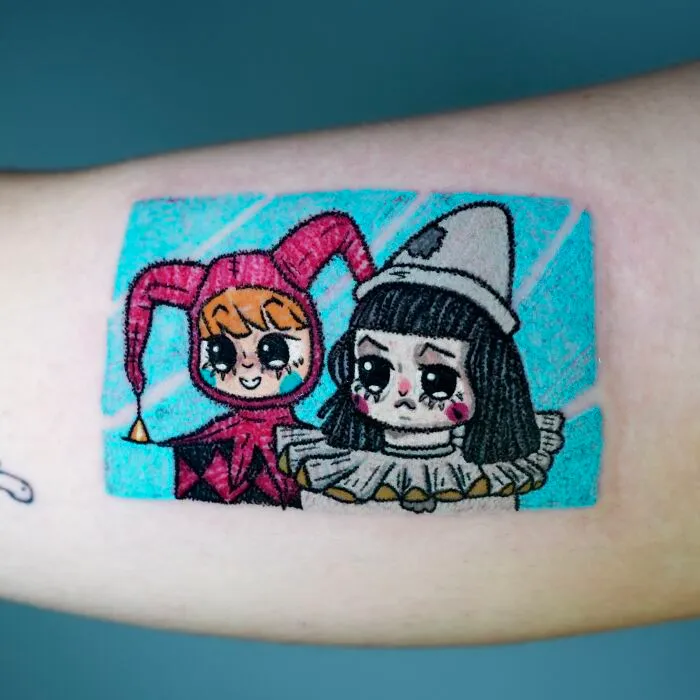 Artistic crayon drawing-inspired tattoo of two characters in jester outfits, capturing the essence of childhood creativity.