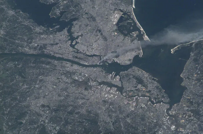An aerial view of a city with smoke rising from a specific area, a rare and fascinating photo from American history.