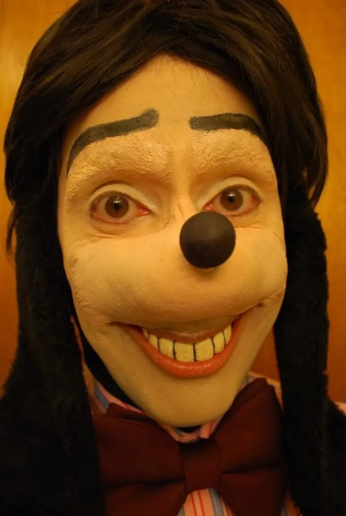 Unsettling photo of a person in a creepy Goofy costume, with unnerving eyes and a fixed smile.