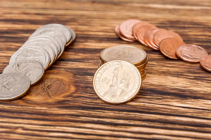 Coins and money on a wooden table, representing the real deals and financial signs from the universe.