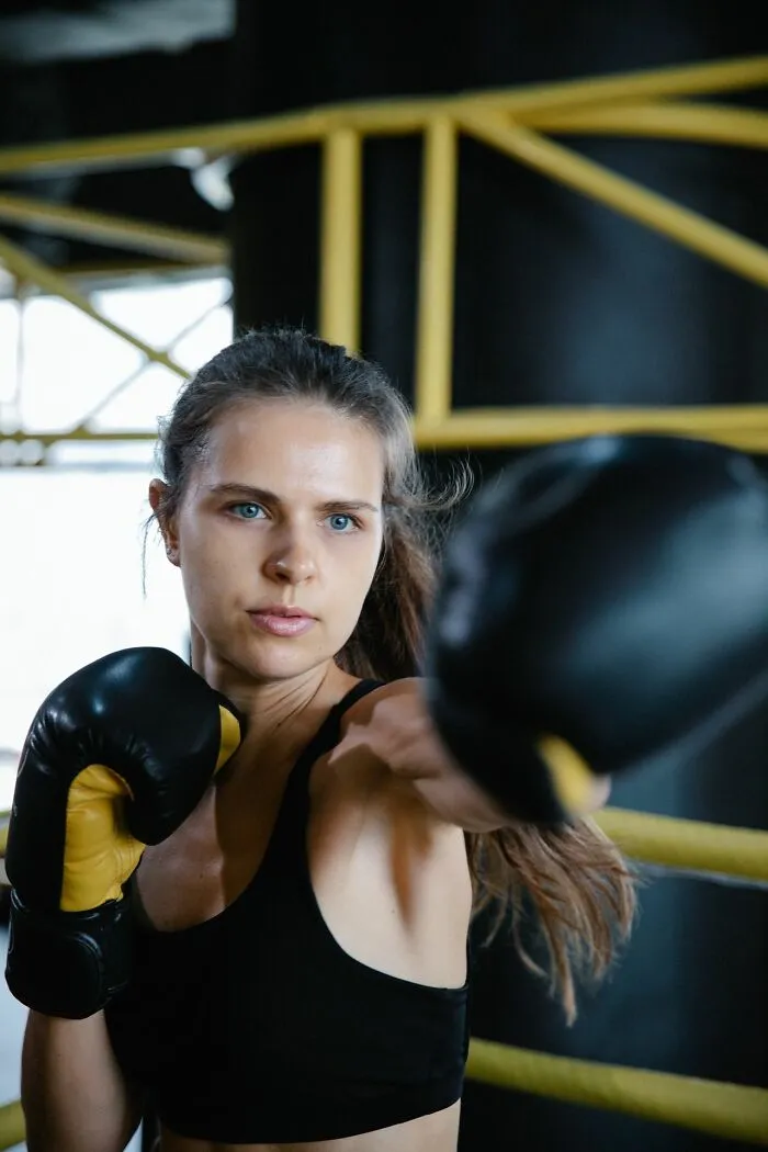 Woman in boxing gloves in a boxing ring. This image illustrates the savage ways women shut down creepy men.