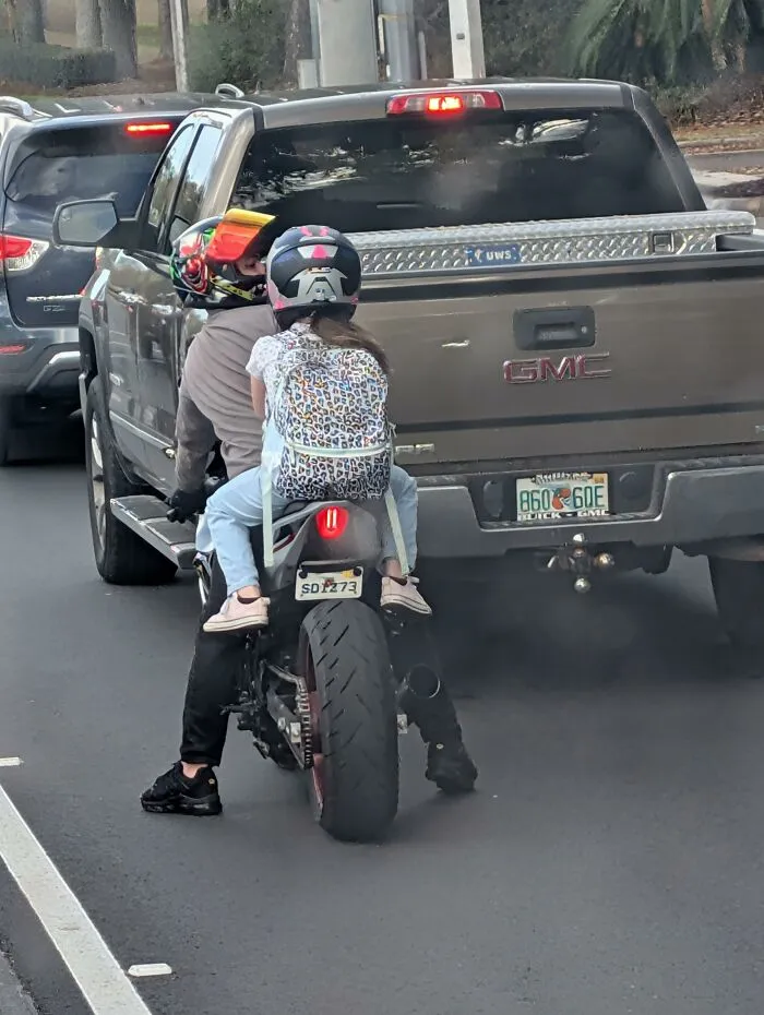 I'm Pretty Sure You Aren't Supposed To Do This. At Least She Had A Helmet On
