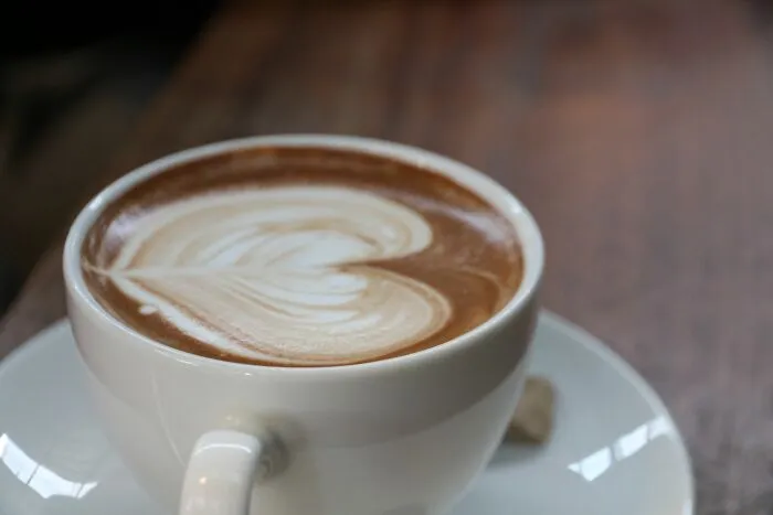 A close-up of a cup of coffee with latte art, representing funny encounters with American tourists.