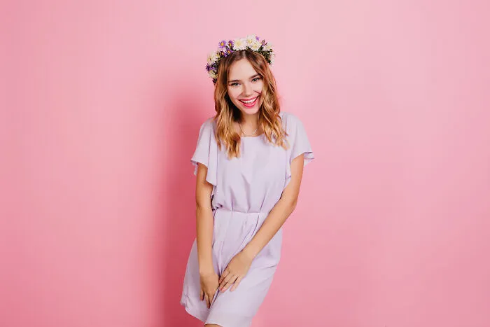 A young woman in a purple dress and flower crown smiles. A firsthand witnessed moment of absurd and hilarious joy.