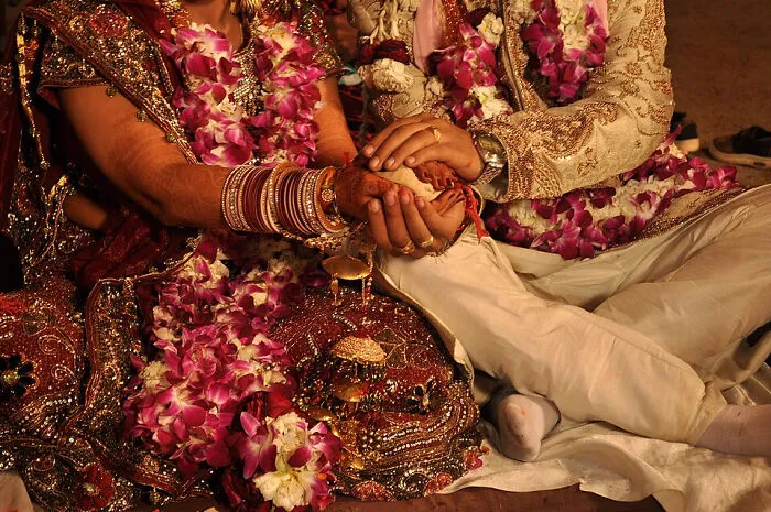 A close-up of a couple's hands during a traditional ceremony, symbolizing amazing world records.