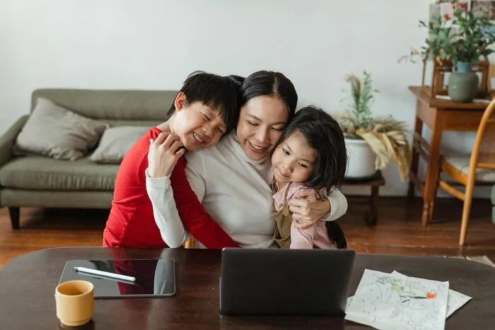 A mother embracing two children, showcasing the complexities of gender roles and toxic femininity.