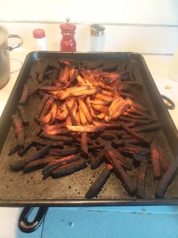 Overcooked and burnt fries on baking tray cooking disaster