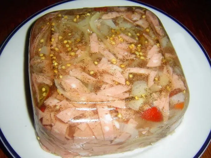 A gelatin mold filled with sausage pieces and onions, highlighting bizarre food combinations
