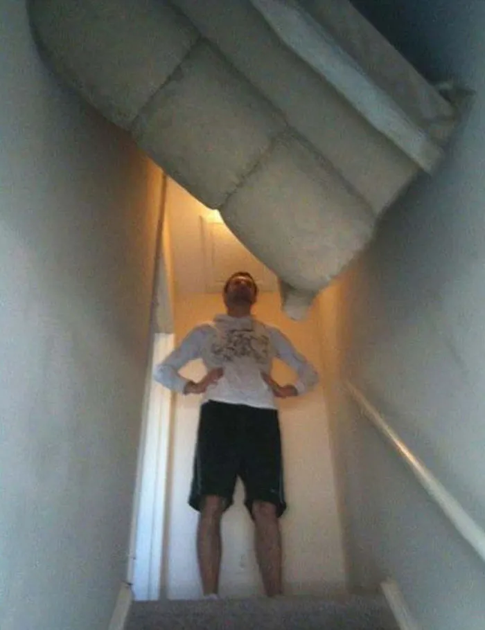 Person stuck with sofa angled awkwardly in narrow stairway