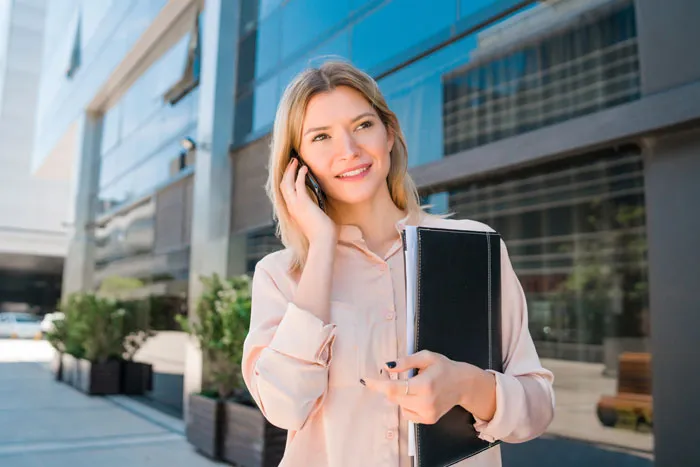 Blonde businesswoman making a call, representing life paths taken by smart kids.
