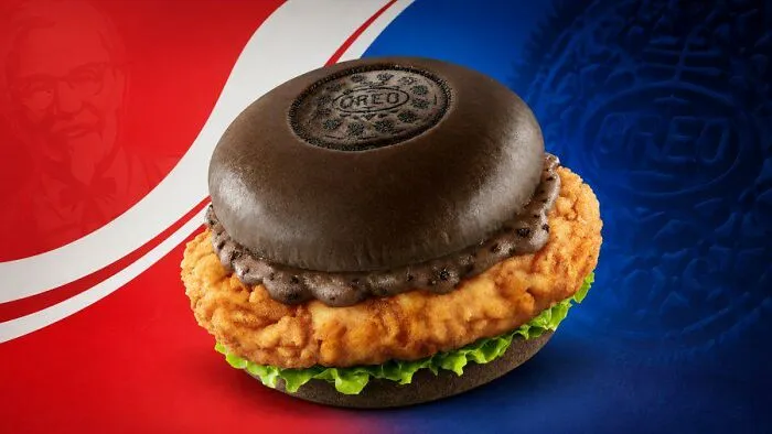 An Oreo burger with a black bun and fried chicken, a weird food combination