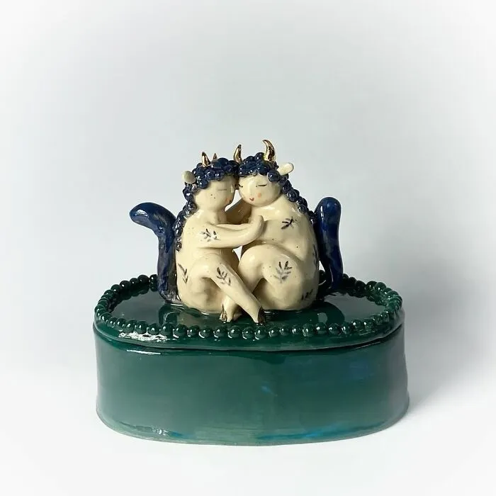Blue and white ceramic sculptures of a cuddling horned couple, perfect for home decor