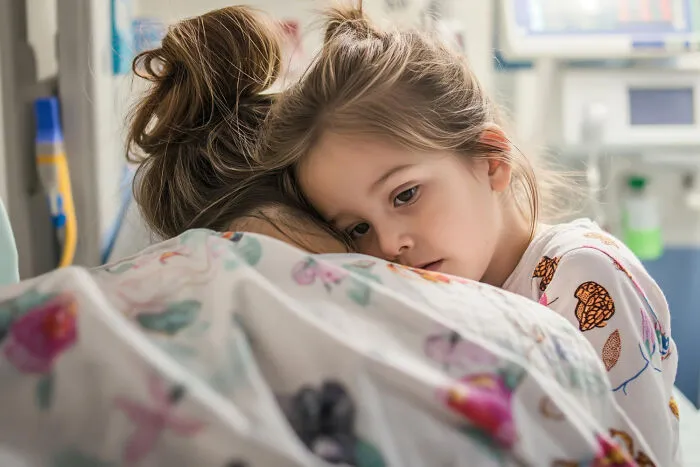 A worried child hugging her mother in a hospital room, highlighting how strange patients and families seek care
