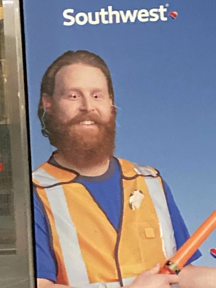 Someone Put Googly Eyes On This Poster At The Airport