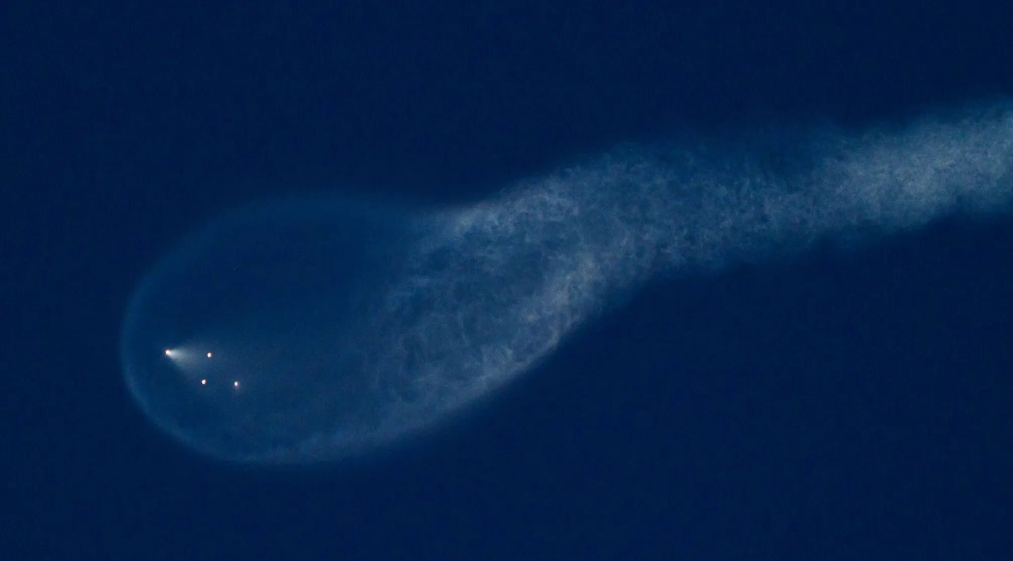 Bright lights creating a foamy oval shape and trail against a dark blue sky, representing UFO and Conspiracy Theories.