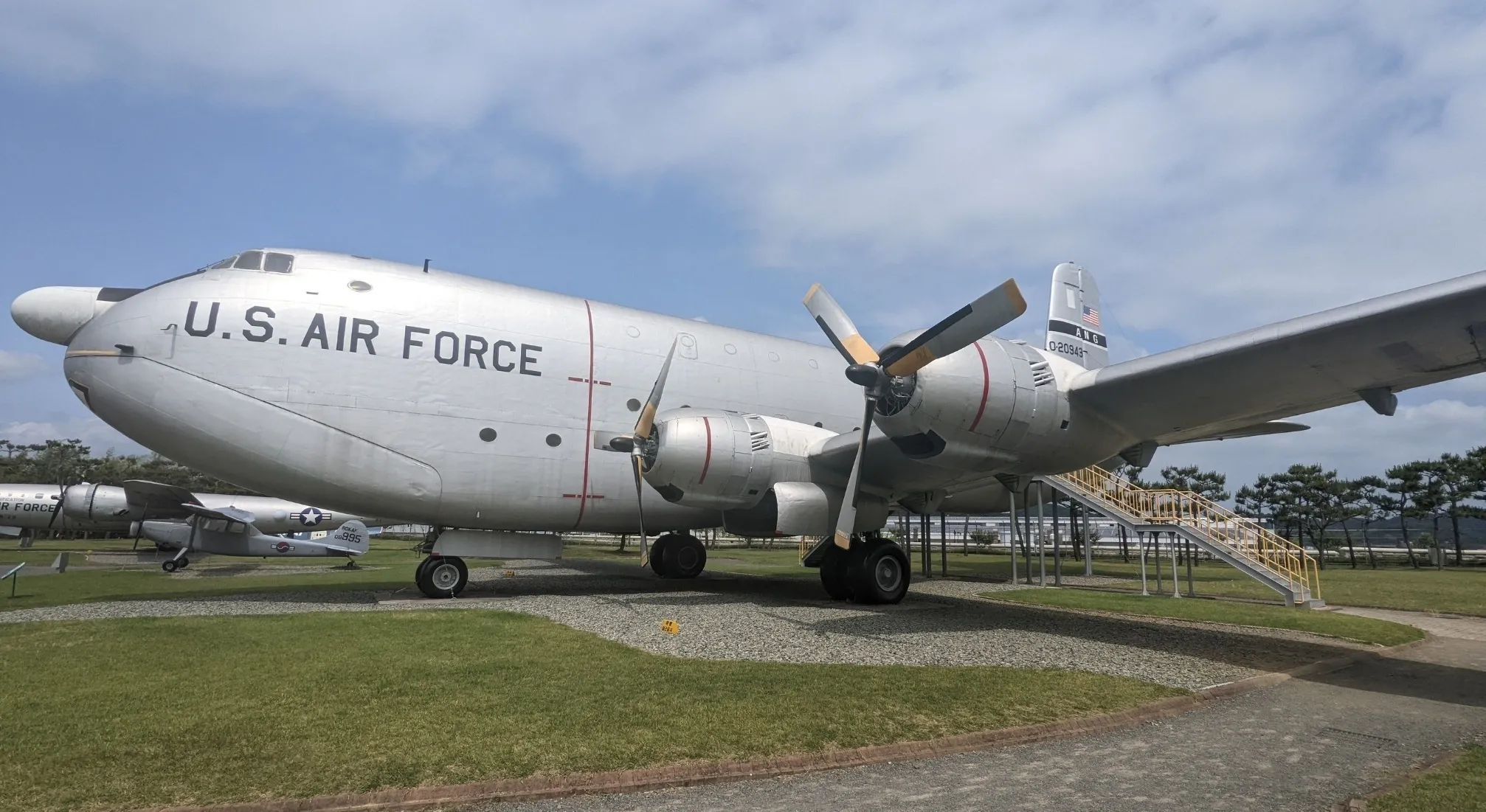 Large U.S. Air Force plane, silver, with propellers, on display. A historical look at UFO and conspiracy theories.