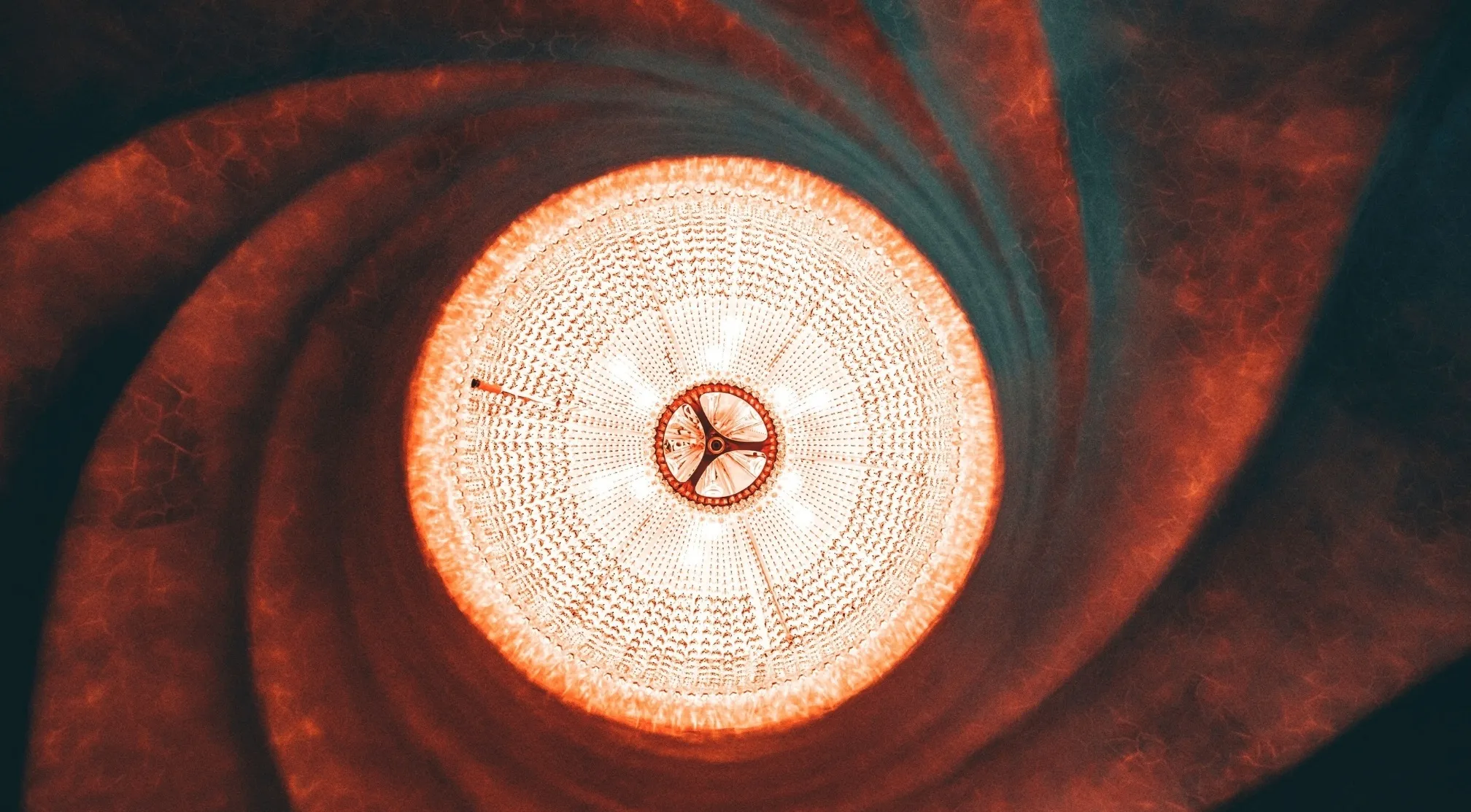 Abstract image with glowing white center and spiraling orange-red textures, hinting at a secret organization or UFO.