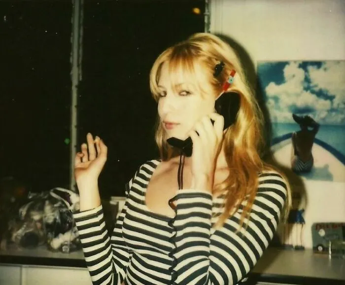 Cute Blond Girl Smokes While Chatting On A Wired-In Sleek Line Phone
