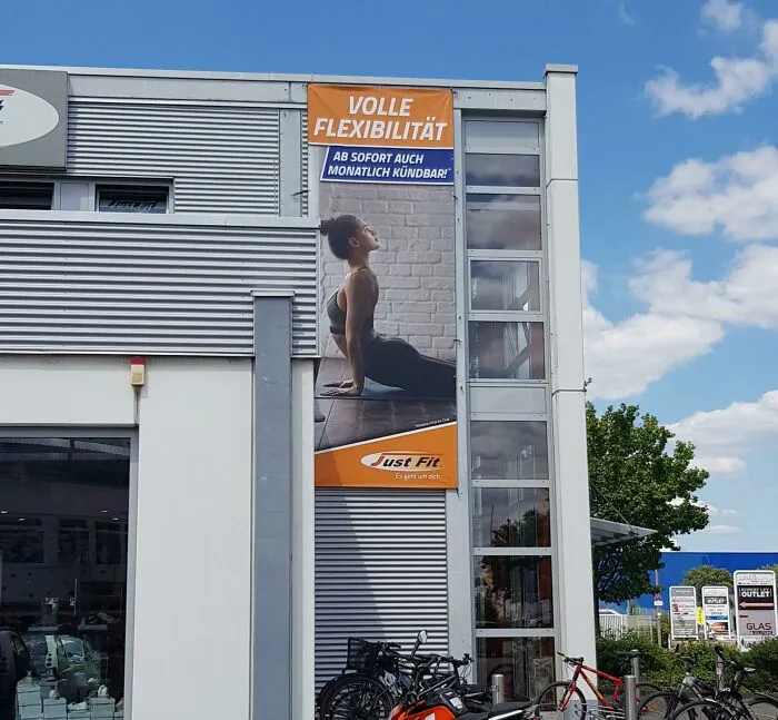 Hilarious ad placements: A fitness ad of a woman doing yoga, placed high on a building, appears to make her tiny.
