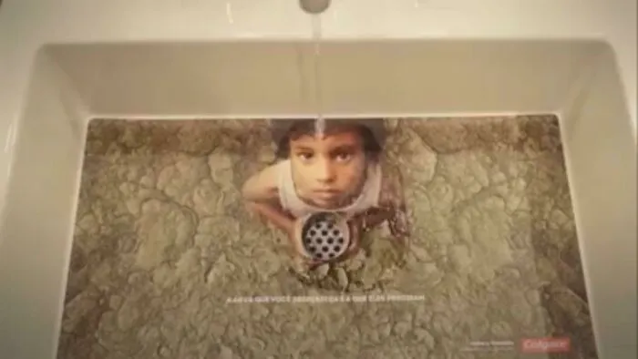 A sink with a drain featuring a child's face and dry, cracked earth around it, a compelling ad placement about water conservation.
