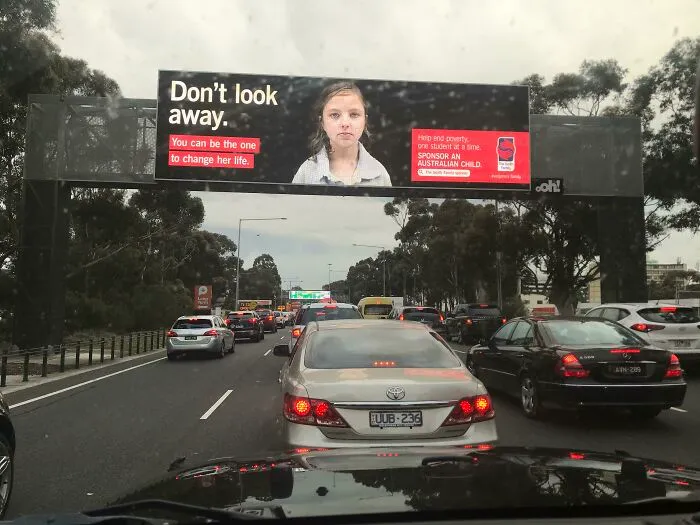 A billboard on a highway with a child's face and text that says, Don't look away, creating hilarious ad placements.