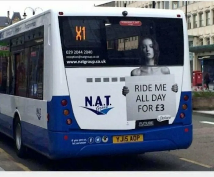 A funny ad placement on the back of a bus with a woman holding a sign saying Ride Me All Day for £3.