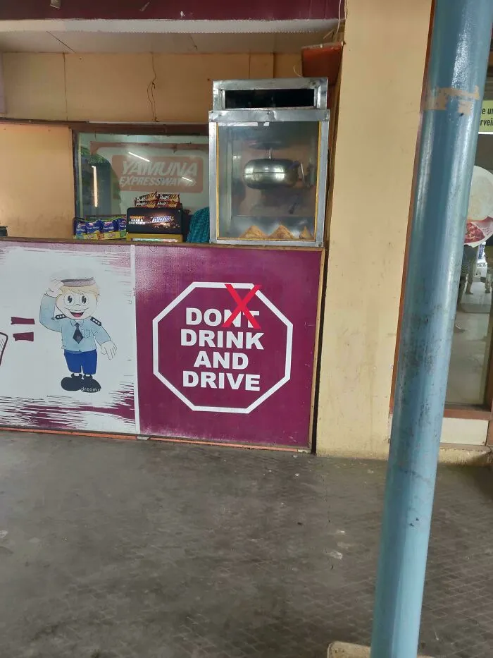 A sign saying dont drink and drive with a red X over the dont, near a food stall, an example of hilarious ad placements.