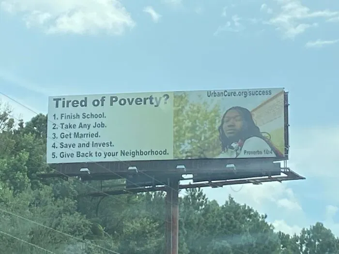 A billboard offering solutions to poverty, reflecting the horrid world's struggles.