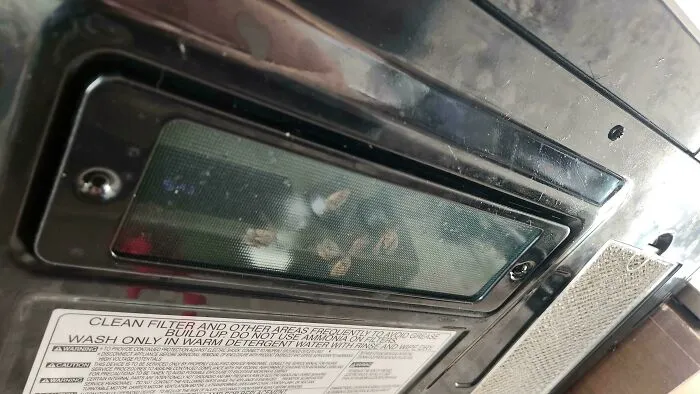 A truly bizarre sight of corn kernels visible through a window in an appliance.