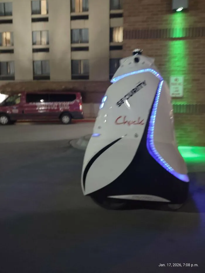 Security robot at night, a stark visual of the American Dream's dystopian nightmare.