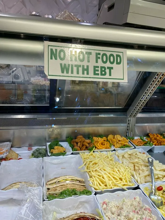 A sign in a deli says No Hot Food With EBT, showing a dystopian nightmare in the American Dream.