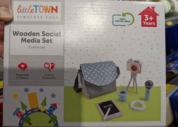 A Little T.O.W.N. Timeless Toys box for a 'Wooden Social Media Set,' showing a dystopian nightmare of modern childhood.