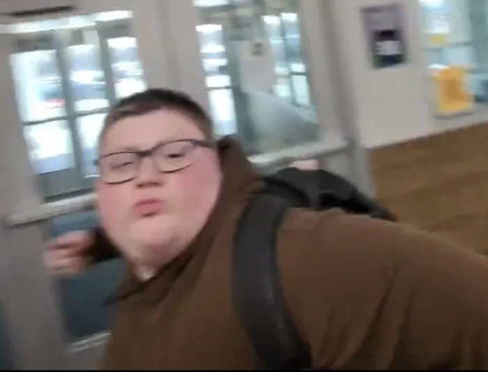 A young, heavy-set person wearing glasses and a backpack makes a funny face, captured in one of the unhinged images.
