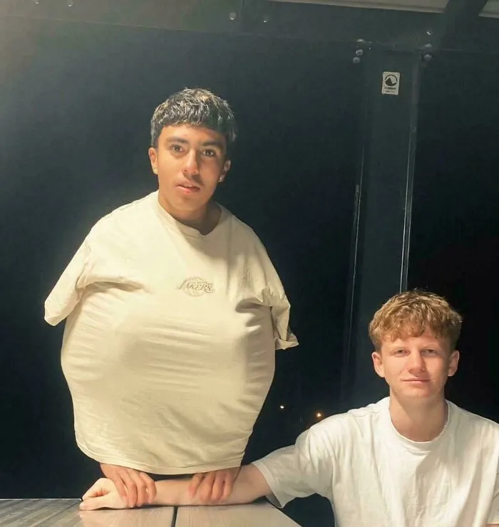Two men create a confusing optical illusion, one appearing to have a tiny body in unhinged images.