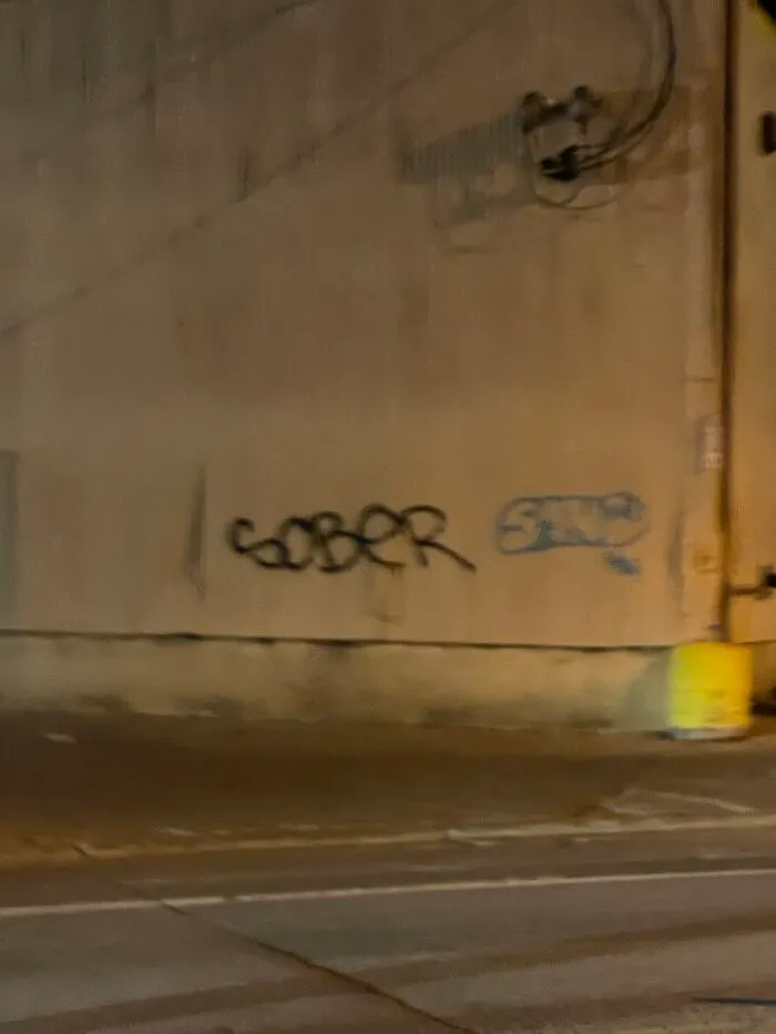 Graffiti on a wall reading 'SOBER' where a small section of the wall appears to be synced just right with the word.