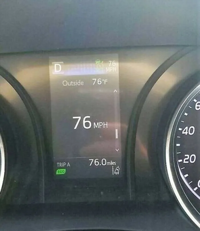 A car dashboard display showing the speed, outside temperature, and trip mileage all synced at 76, a perfectly synced moment.
