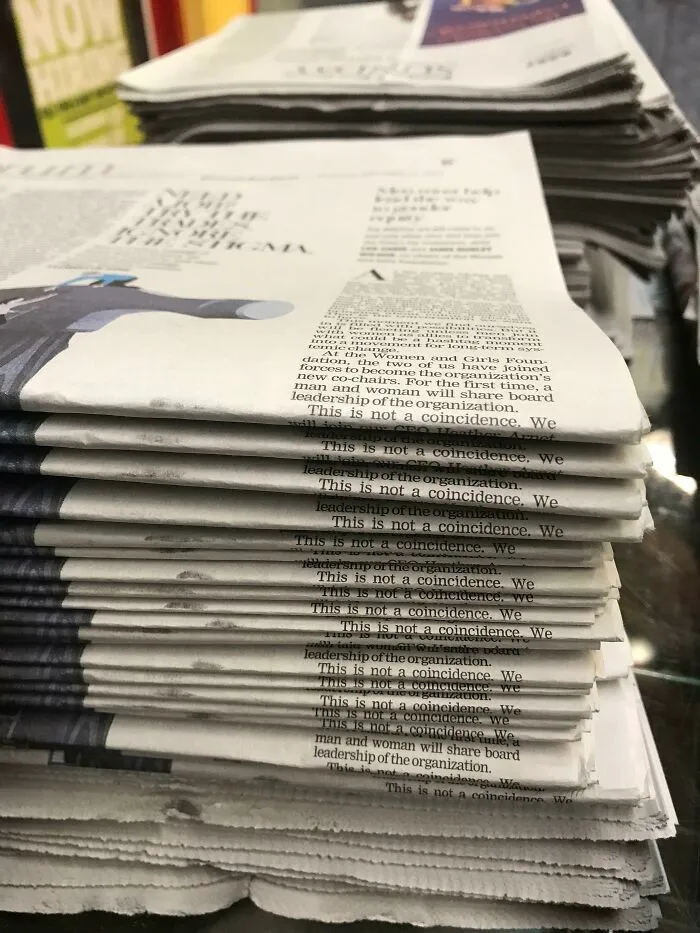 A stack of newspapers with the repeated phrase This is not a coincidence printed down the side, an amazing example of something synced just right.