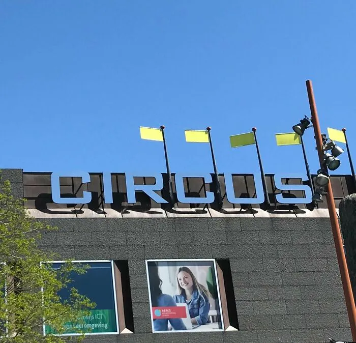 The word CIRCUS atop a building, with yellow flags synced against a clear blue sky, creating a vibrant scene.