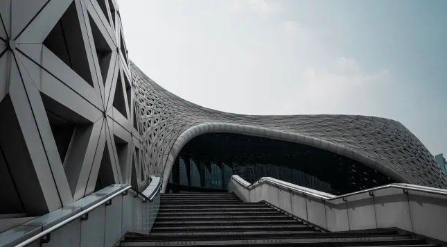 Basic general knowledge quiz question: Modern architecture with intricate geometric patterns and a prominent staircase under a gray sky.