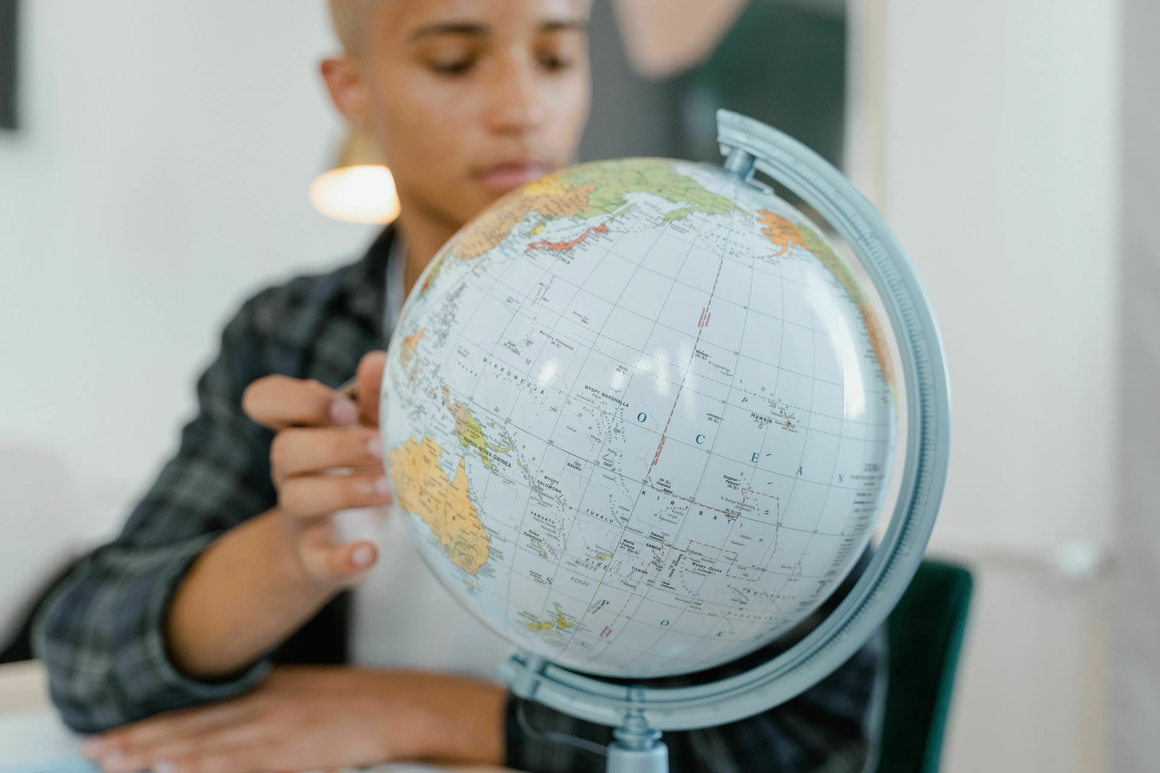Young person looking at a globe, for a general geography knowledge quiz on cities and famous landmarks.