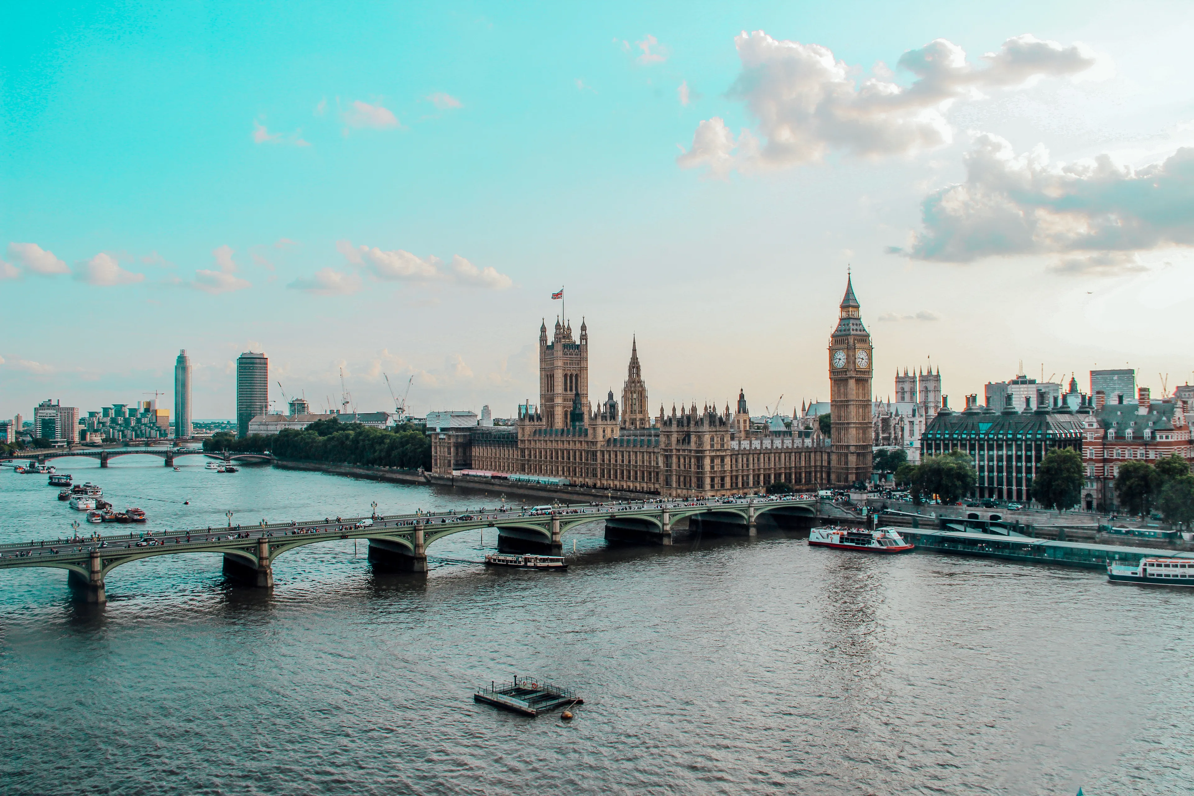 General Geography Knowledge Quiz: A scenic view of the River Thames flowing through London, with boats and historic buildings like Big Ben.