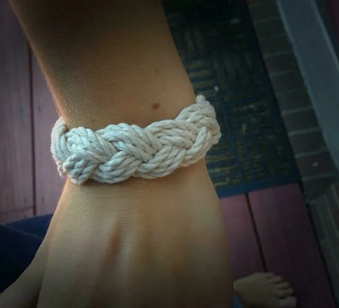 Braided rope bracelet on wrist representing Gen X childhood memories