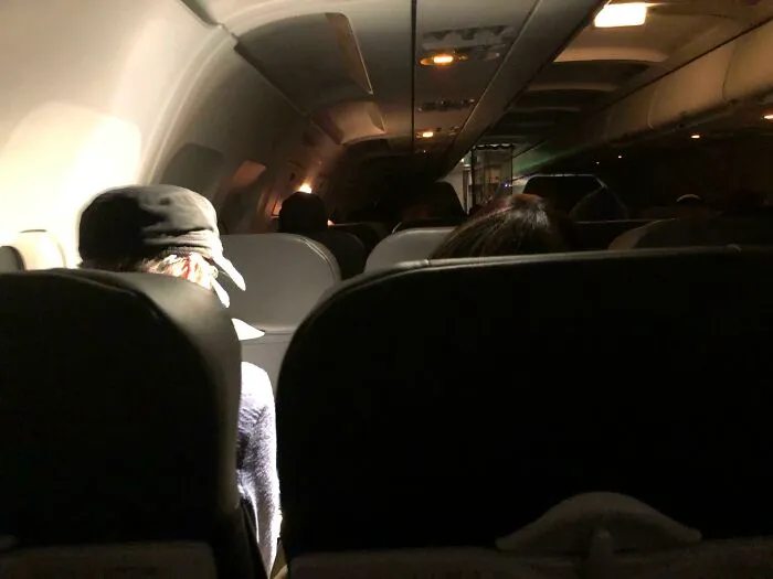 This Woman In A Darkened Cabin Of Our Plane At 5:45 In The Morning, Leaving Only Her Light On So She Can Watch A Video On Her iPad