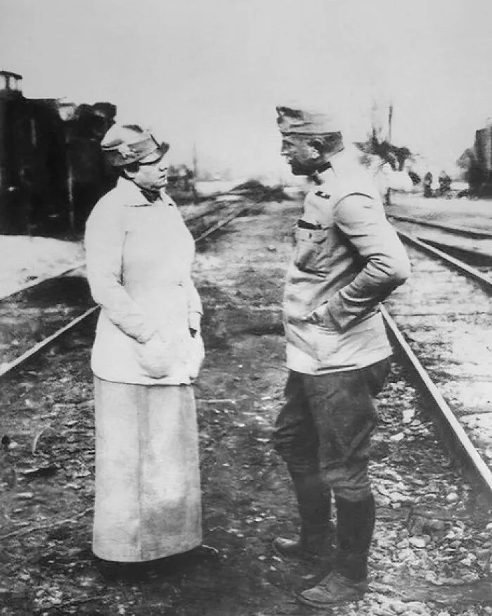 A woman and a man stand on train tracks, a moment captured in Women in History.