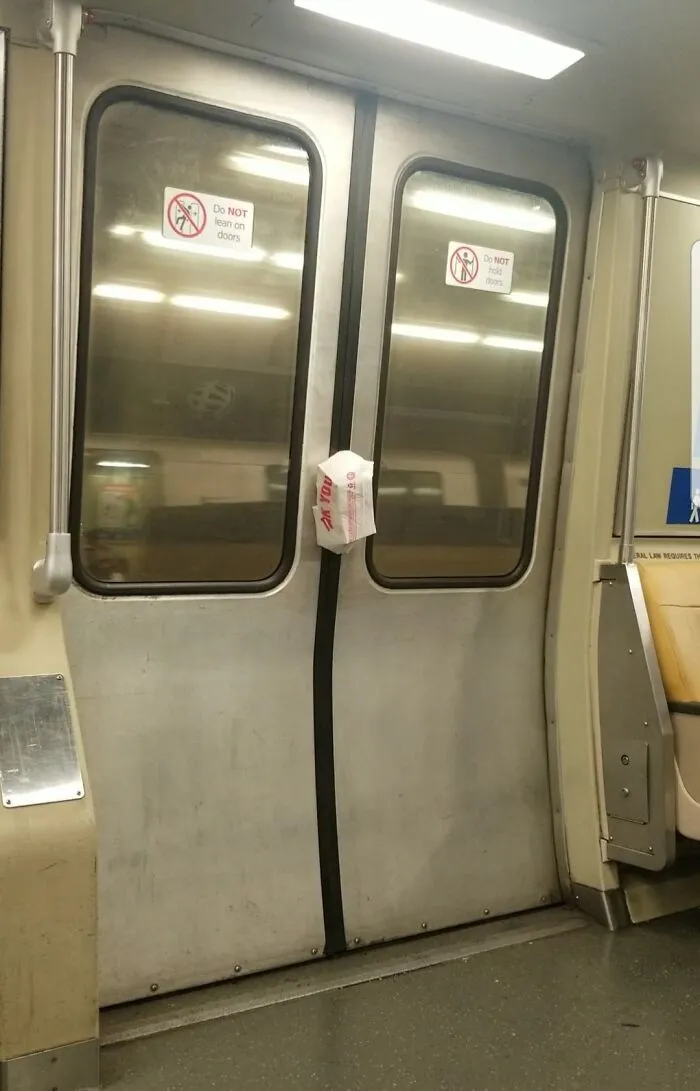 Takeaway bag caught in the closed doors of a public transport train