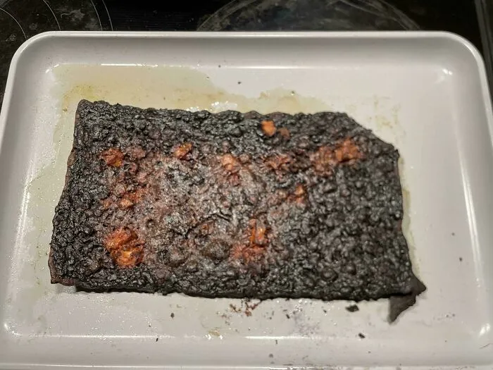 Overcooked burnt rectangular food on a baking sheet