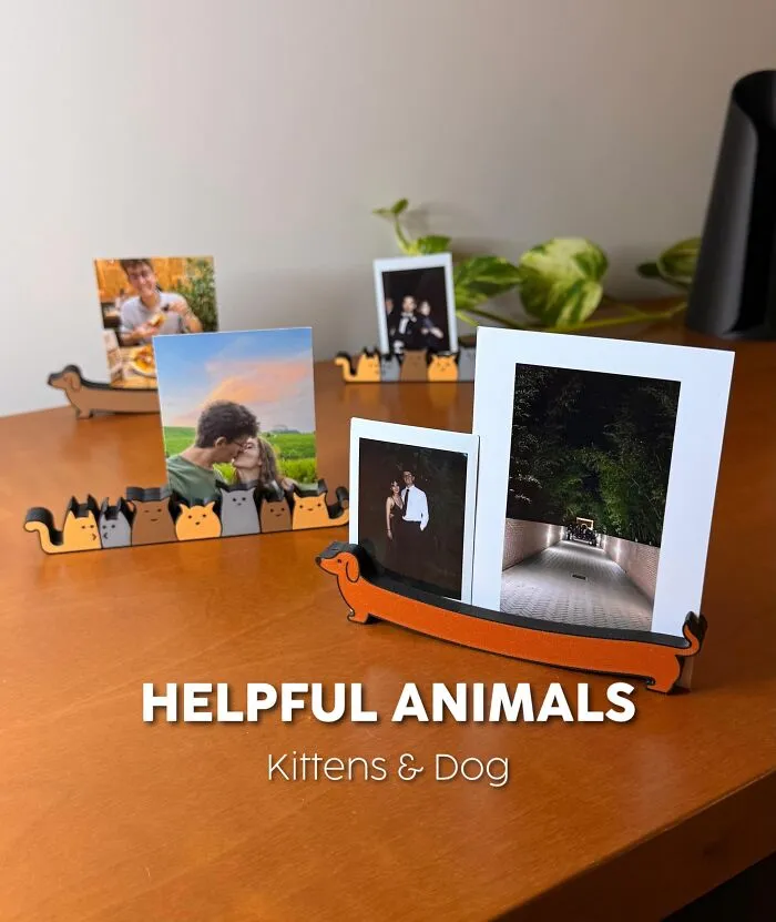 3D printed helpful animals photo holders shaped as kittens and dogs on a table