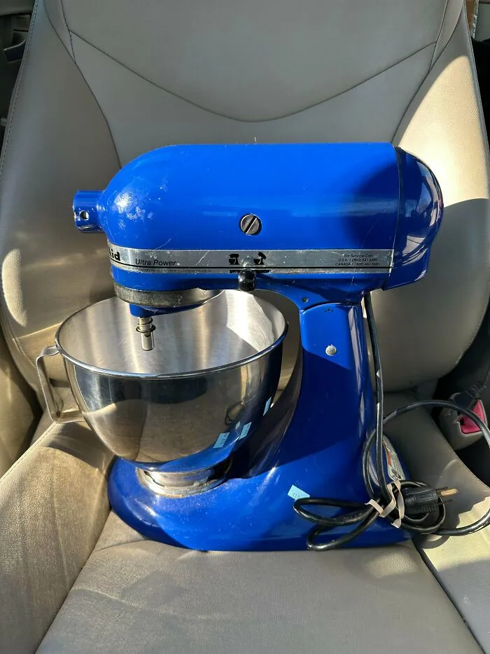 A vibrant blue KitchenAid stand mixer with a stainless steel bowl, a lucky find from a thrift store